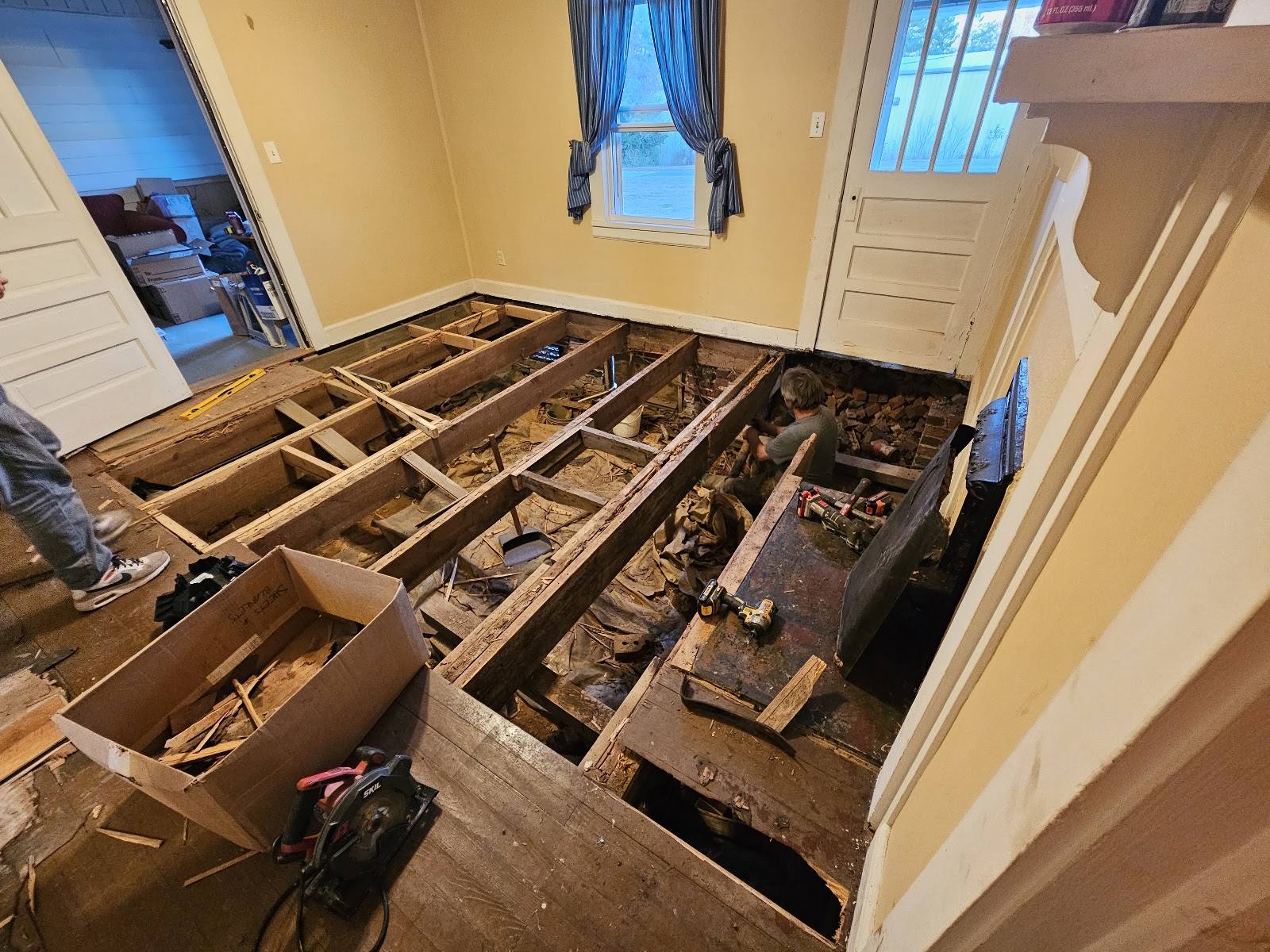 Room after the old floor and subfloor were removed, exposing the joists