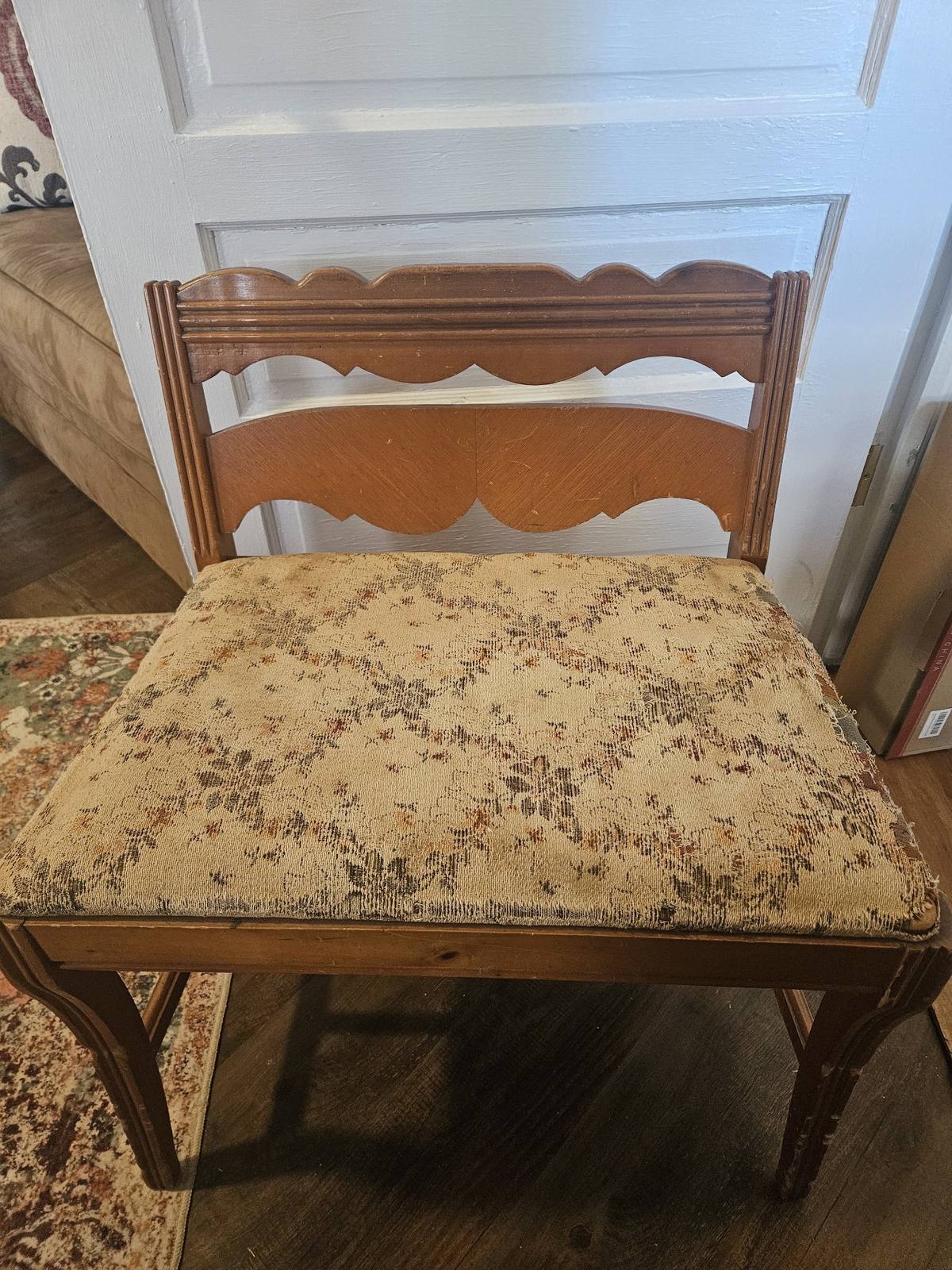 Vintage vanity bench before refinishing, with worn floral upholstery
